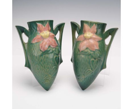 This pair of Roseville Pottery wall vases from the Clematis pattern features large pink clematis blossoms in full relief agai