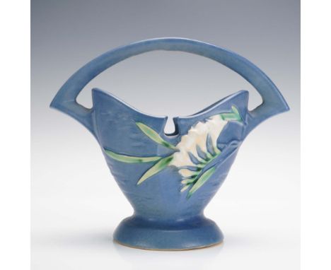This Roseville Pottery basket vase features the Freesia pattern in shape number 390-7, designed with a gracefully arched hand