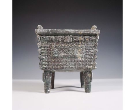 Inspired by ancient Chinese fang ding ritual vessels, this rectangular metal piece features ornate geometric and studded patt