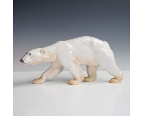 Crafted by the esteemed Danish porcelain manufacturer Bing &amp; Grondahl, this elegant figurine depicts a polar bear mid-str