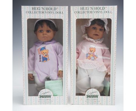 Pair of Seymour Mann Hug 'N Hold collector vinyl dolls, each presented in its original printed box with cellophane front. The