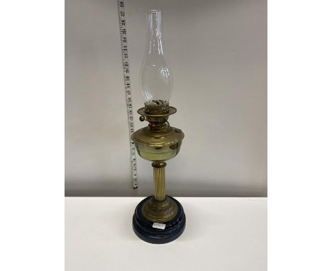 A Victorian brass based oil lamp with glass chimney h65cm, shipping unavailable