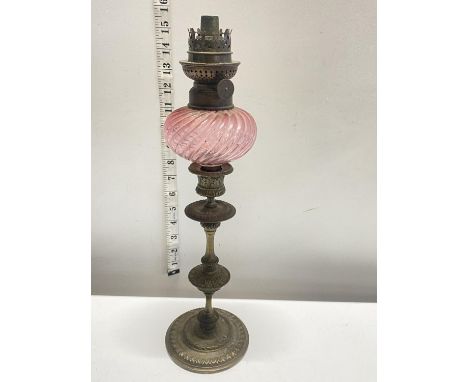 A smaller brass oil lamp with a cranberry glass reservoir h38cm, shipping unavailable