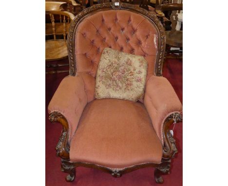 A mid-Victorian heavily floral carved mahogany framed showframe scroll nursing chair, with pink dralon button back upholstery