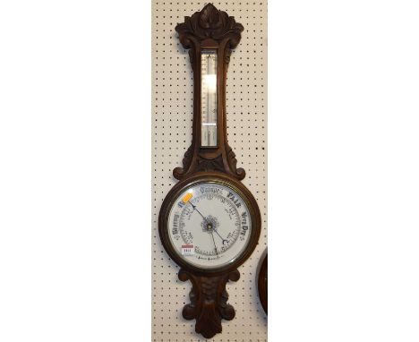 A mid-20th century floral relief carved oak two-dial aneroid barometer