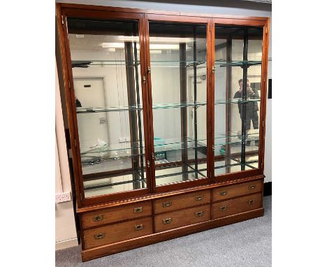 An Edwardian mahogany three door shop display cabinet, attributed to E. Pollard & Co, the glazed doors enclosing three heavy 