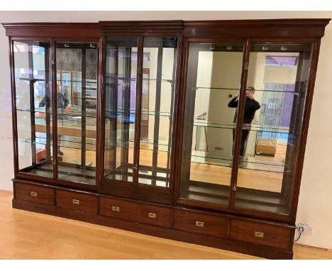 An Edwardian mahogany breakfront six door shop display cabinet, by E. Pollard & Co, the glazed twin door sections each enclos