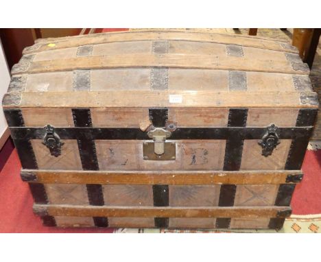 An early 20th century canvas, wood and metal bound domed hinge topped travelling trunk, w.83cm 