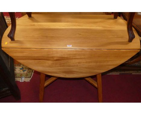 An Ercol pine compact kitchen table, raised on square cut supports united by X-framed stretcher, length 115cm