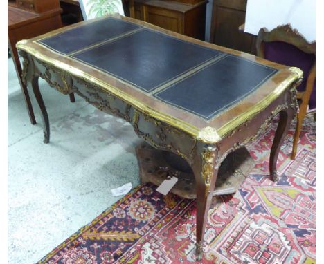 BUREAU PLAT, Louis XV style walnut with a tooled black leather top with applied decorative gilt metal mounts with three friez