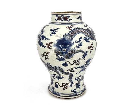 A Chinese vase, Kangxi period, 1662-1722, of baluster form, boldly decorated in underglaze blue and red, depicting four clawe