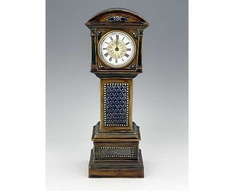A Doulton stoneware novelty time piece, 1884, modelled as a longcase clock, moulded foliate panels of repeating leaf motifs w