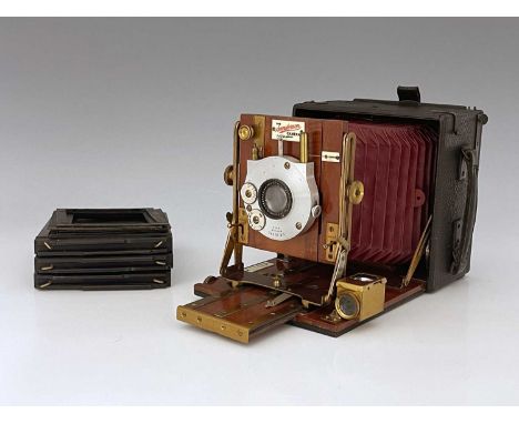 A Sanderson 4x5 Field concertina camera, red bellows, brass, and mahogany fittings with a C.P. Goerz lens, ivorine plaques, 1