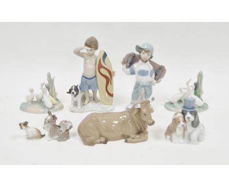 Lladro figure&nbsp;of a boy surfer with his dog, 19cm high, boxed, Nao figure&nbsp;of a boy with skateboard, four various Nao