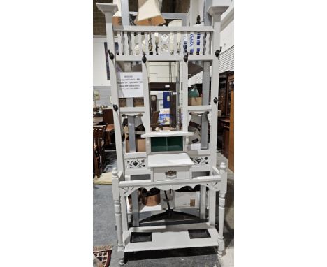 Late 19th/early 20th century oak hallstand, the back with a central bevelled edge mirror, shelf and coat hooks, over a glove 