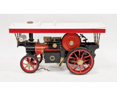Scratch-built live steam metal scale model of a traction engine, red and black with a red and white wooden canopy, 49cm long