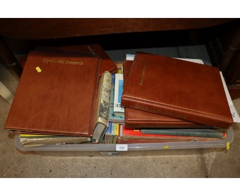 A plastic crate of books to include First Day cover albums, Enid Blyton, Rupert The Bear etc.