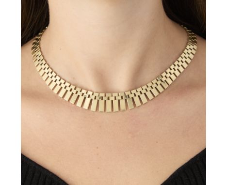 14k yellow gold necklace comprised of links reminiscent of watch bracelets with graduating fringe toward the center. All indi