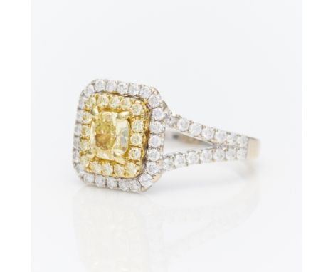 18k white and yellow gold diamond ring with a cushion shaped light yellow diamond surrounded by 67 small diamonds. The center