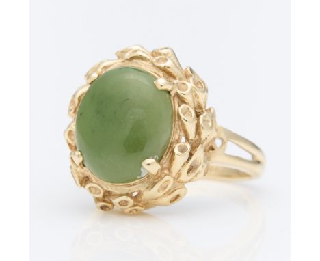 14k yellow gold ring set with central oval jade cabochon, surrounded by a textured wreath of yellow gold. On a split shank. M