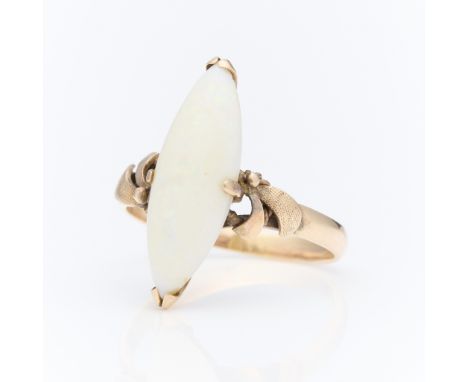 14k yellow gold ring set with central navette form white opal. The shoulders of the ring accented with textured and curling r