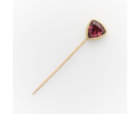 14k yellow gold stick pin surmounted with a bezel set triangular cut garnet. Unmarked, tested 14k.Length: 32.05 mm. Gross wei