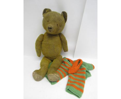 A vintage straw filled jointed mohair teddy bear with knitted cardigan, breeches and scarf, 53cm tall, for restoration