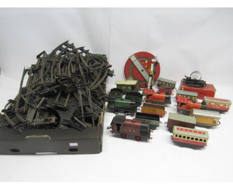 A collection of playworn 0 gauge model railway rolling stock and accessories including Hornby LMS 0-4-0 clockwork locomotive 