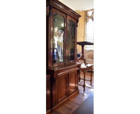 A Victorian mahogany bookcase on cupboard, 107 cm wide, an oak table, a tripod table and a mirror (4) 