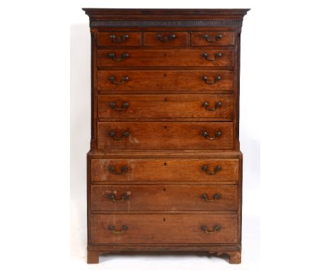 A George III oak chest on chest, the moulded cornice above a fluted frieze, with three short and four graduated long drawers,