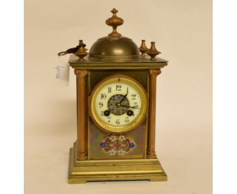 An Edwardian mantel clock, the 7.5 cm diameter dial with Arabic numerals, in a brass and champleve enamel case, 27 cm high   