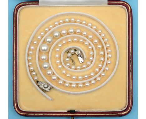 A graduated pearl necklace, on an Art Deco white coloured metal and diamond clasp, set brilliant and baguette cut stones  See