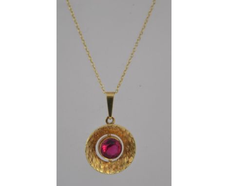 A vintage modernist rolled gold pendant necklace the pendant being set with a red stone within a textured surround, the chain