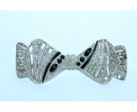 A 1930's 18ct white gold Art Deco bow brooch encrusted with diamonds with trombone  clasp. Marked W within a cartouch and ano