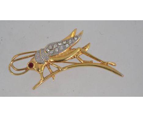 A large vintage figural brooch pin in the form of a grasshopper with rhinestone set wings and eye with roller clasp. Measures