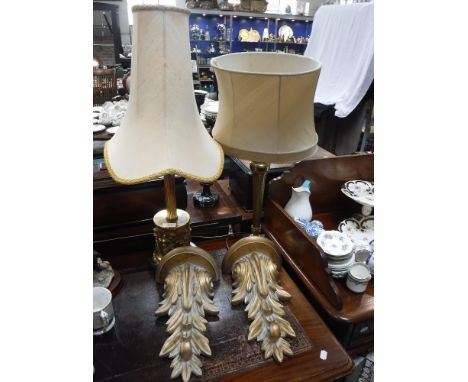 A GILT METAL TABLE LAMP, with embossed cherubs, another similar and a pair of gilt 'acanthus' wall brackets