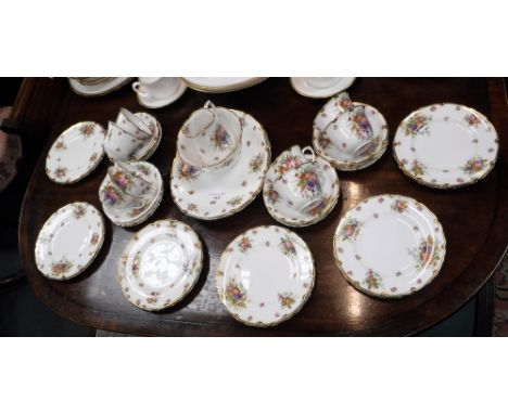 A ROYAL DOULTON TEA SERVICE decorated with floral sprays and roses within a gilt border