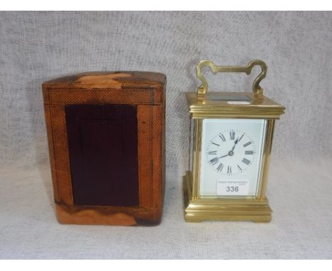 A BRASS-CASED CARRIAGE CLOCK with a painted enamel dial and bevelled glass panels, striking on a gong, in a leather carrying 