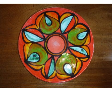 A LARGE POOLE DELPHIS POTTERY CHARGER with red and orange stylised decoration, marked