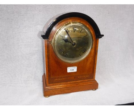 AN EDWARDIAN OAK-CASED MANTEL CLOCK with polished brass dial, 12.5" high