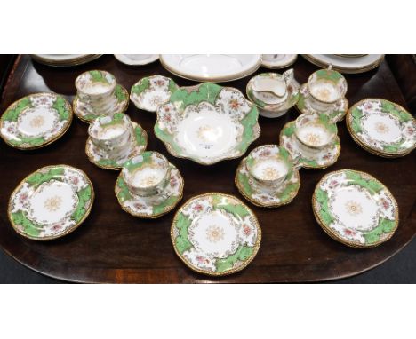 A COALPORT TEA SERVICE, decorated with sprays of flowers within a green and gilt border