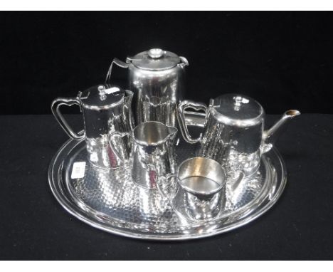 A VINTAGE OLDE HALL STAINLESS STEEL FOUR PIECE TEASET WITH TRAY, with a planished finish and one other hot water pot (6)