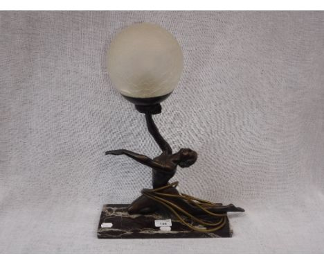 A REPRODUCTION ART DECO TABLE LAMP in the form of a dancer, her hand supporting a crackle frosted glass shade, 18" high (over