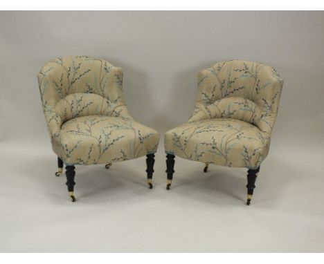 A a pair of late Victorian nursing chairs, 19th century, each later upholstered in bright cream and blue bud floral fabric an
