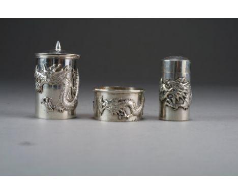 A Chinese silver three-piece cruet set, circa 1910-20, unsigned, of cylindrical form and applied with dragons, comprising ope