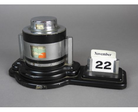An Art Deco desk barometer 1930s, black metallic and aluminium finish and with calendar to one side, 26cm wide, 13cm high