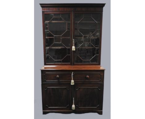 An early 19th century mahogany high secretaire bookcase, the dentil moulded cornice over two astragal glazed doors opening to