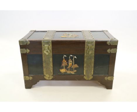 A Chinese brass bound and inlaid hardwood trunk, late Qing Dynasty, of rectangular form and raised on bracket feet, the top a
