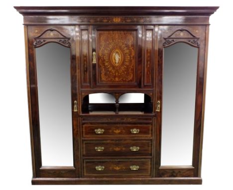 An Edwardian mahogany and inlaid bedroom suite comprising a triple wardrobe with classical mask and foliate inlaid frieze abo