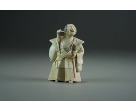 A Japanese ivory netsuke of a Samurai, Meiji period, modelled standing and wearing traditional robes, 7cm high.